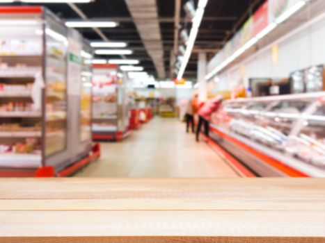 Light wooden board empty table in front of blurred background. Perspective light wood over blur in supermarket - can be used for display or montage your products. Mockup for display of product.