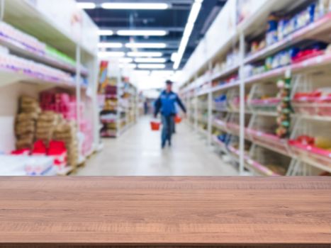 Brown wooden board empty table in front of blurred background. Perspective dark wood over blur in supermarket - can be used for display or montage your products. Mockup for display of product.