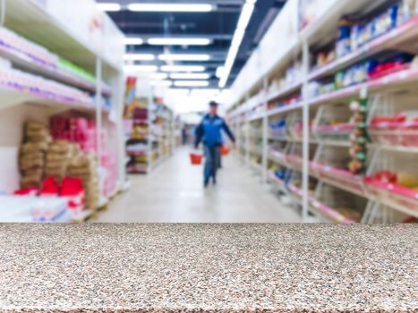 Marble board empty table in front of blurred supermarket - can be used for display or montage your products. Mockup for display of product.