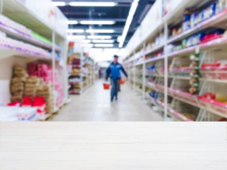 White wooden board empty table in front of blurred background. Perspective white wood over blur in supermarket - can be used for display or montage your products. Mockup for display of product.