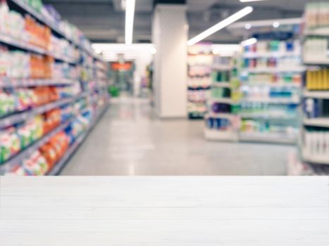 White wooden board empty table in front of blurred background. Perspective white wood over blur in supermarket - can be used for display or montage your products. Mockup for display of product.