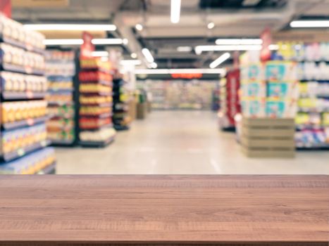 Brown wooden board empty table in front of blurred background. Perspective dark wood over blur in supermarket - can be used for display or montage your products. Mockup for display of product.