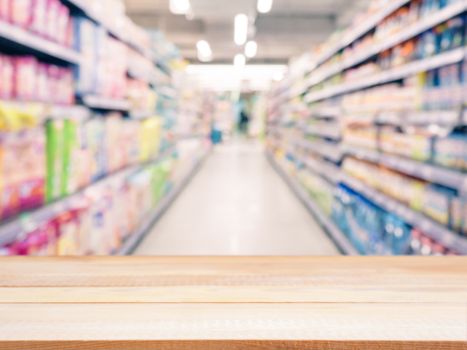 Light wooden board empty table in front of blurred background. Perspective light wood over blur in supermarket - can be used for display or montage your products. Mockup for display of product.