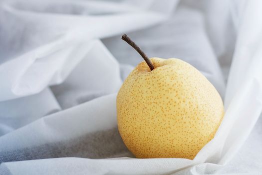 Yellow pear on a white tablecloth.