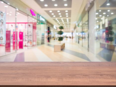 Brown wooden board empty table in front of blurred shopping mall - can be used for display or montage your products. Mockup for display of product.