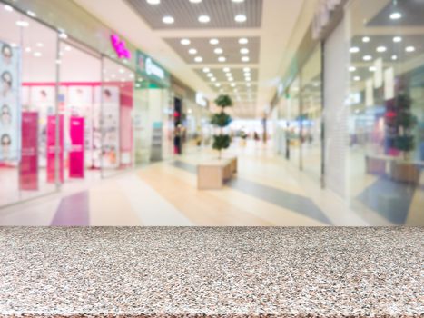 Marble board empty table in front of blurred shopping mall - can be used for display or montage your products. Mockup for display of product.