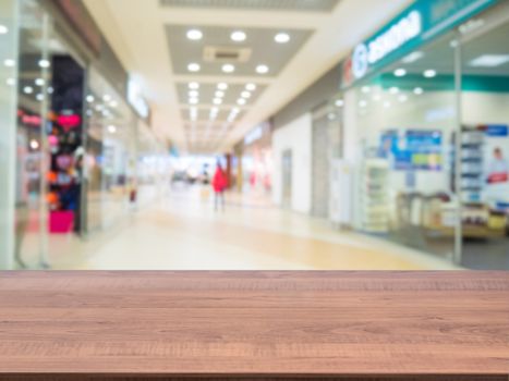 Brown wooden board empty table in front of blurred shopping mall - can be used for display or montage your products. Mockup for display of product.