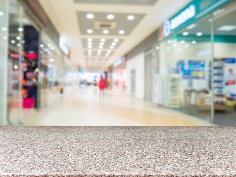 Marble board empty table in front of blurred shopping mall - can be used for display or montage your products. Mockup for display of product.