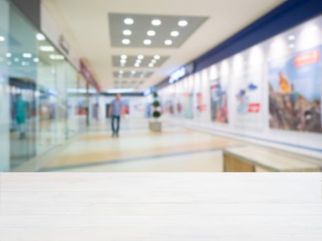 White wooden board empty table in front of blurred shopping mall - can be used for display or montage your products. Mockup for display of product.