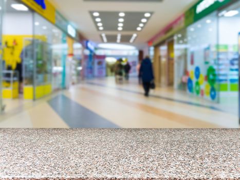 Marble board empty table in front of blurred shopping mall - can be used for display or montage your products. Mockup for display of product.