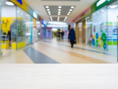 White wooden board empty table in front of blurred shopping mall - can be used for display or montage your products. Mockup for display of product.