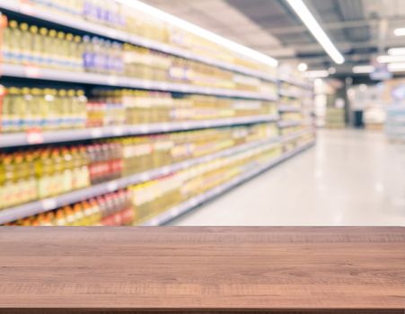 Brown wooden board empty table in front of blurred background. Perspective dark wood over blur in supermarket - can be used for display or montage your products. Mockup for display of product.