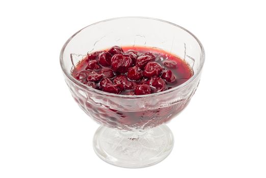 Cherry jam with whole fruits in the glass dessert stem bowl on a light background
