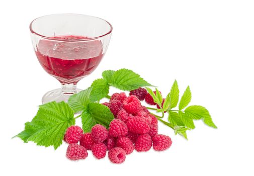 Raspberry jam in the glass dessert stem bowl with pile of the fresh cultivated red raspberries and raspberry branch with leaves in the foreground on a light background
