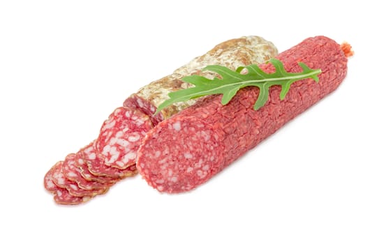 Partly cut salami and partly sliced other salami and fresh leaf of the arugula on them on a light background
