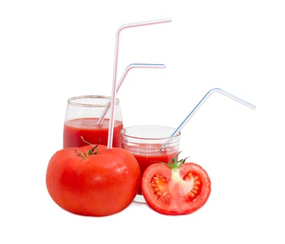 Big fresh whole tomato with bendable drinking straw inserted into it, half of the tomato and two different glasses with tomato juice and drinking straws on a light background
