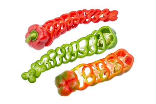 Red, green and orange-green fresh bell peppers sliced by rings on a light background
