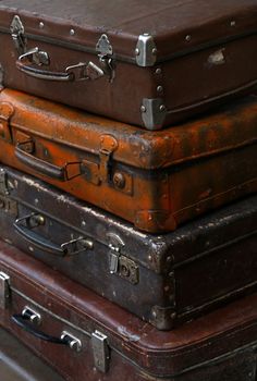 Stack of four old vintage antique grunge travel luggage brown leather suitcase trunks, close up, high angle side view