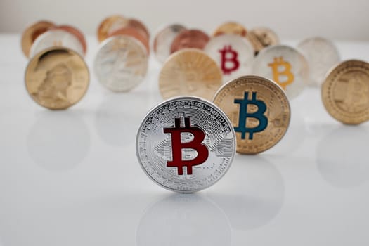 Digital currency physical red bitcoin coin near other bitcoins.