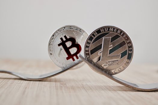 Digital currency physical silver litecoin coin and bitcoin with red sign.
