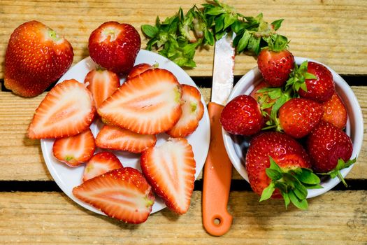 Delicious strawberry in home cooking on wooden table, black background.