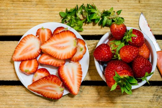 Delicious strawberry in home cooking on wooden table, black background.