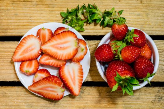 Delicious strawberry in home cooking on wooden table, black background.