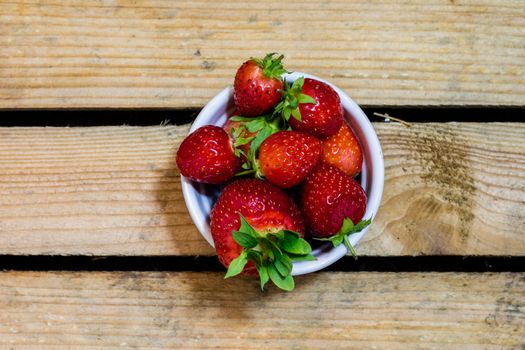 Delicious strawberry in home cooking on wooden table, black background.