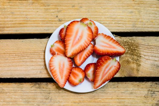 Delicious strawberry in home cooking on wooden table, black background.