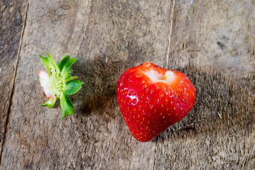 Delicious strawberry in home cooking on wooden table, black background.