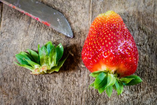 Delicious strawberry in home cooking on wooden table, black background.