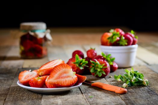 Delicious strawberry in home cooking on wooden table, black background.