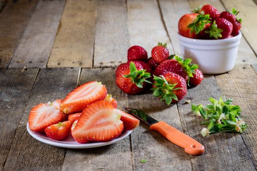 Delicious strawberry in home cooking on wooden table, black background.