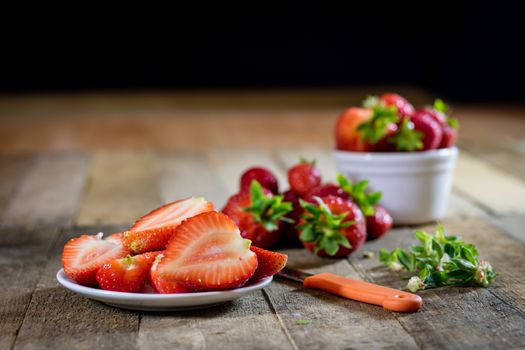 Delicious strawberry in home cooking on wooden table, black background.