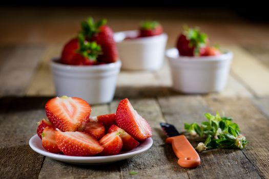 Delicious strawberry in home cooking on wooden table, black background.