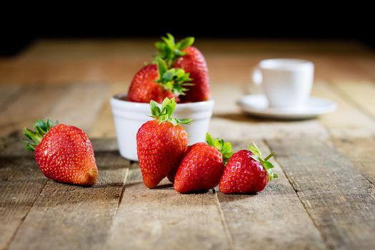 Delicious strawberry in home cooking on wooden table, black background.