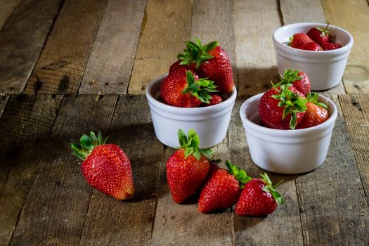 Delicious strawberry in home cooking on wooden table, black background.