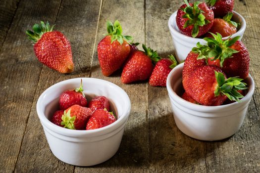 Delicious strawberry in home cooking on wooden table, black background.