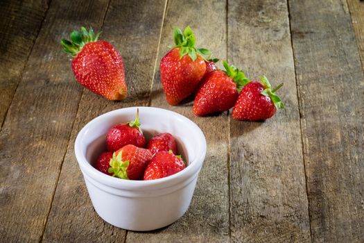 Delicious strawberry in home cooking on wooden table, black background.