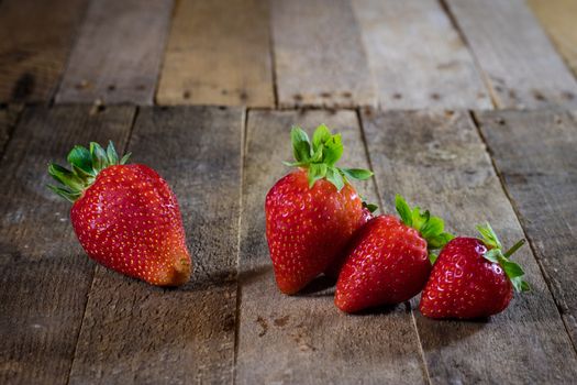 Delicious strawberry in home cooking on wooden table, black background.