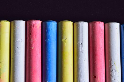 Macro colorful writing chalks isolated in black