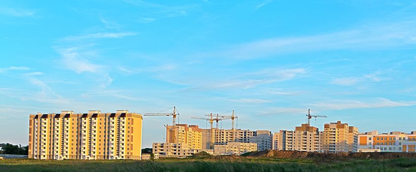 A view on the construction of multi-storey residential buildings on a summer evening.