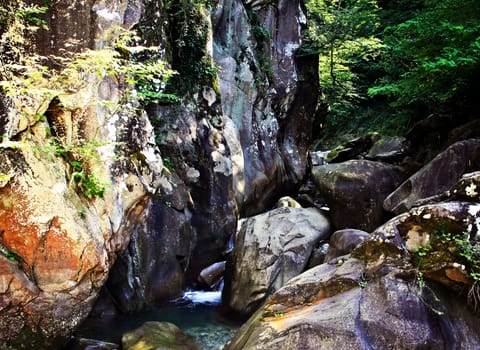 Huge boulders and a small river in the mountains of the North Caucasus.