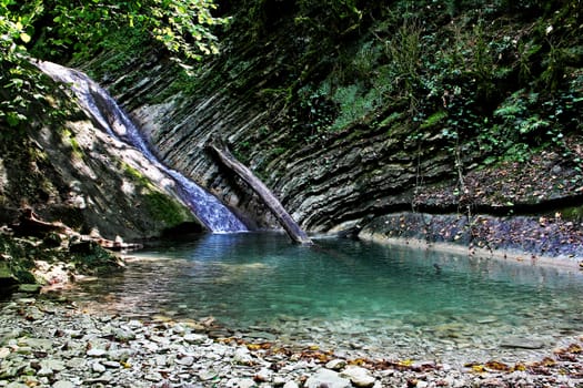 A small picturesque waterfall in the mountains of the North Caucasus.