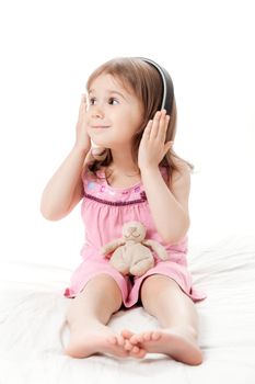 the little girl listens to music in earphones