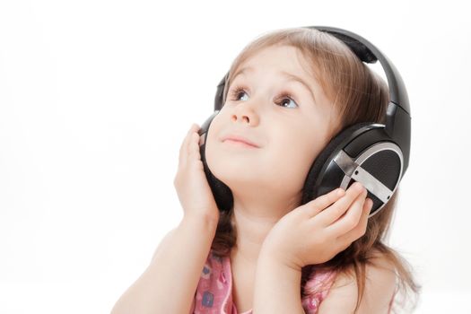 the little girl listens to music in earphones