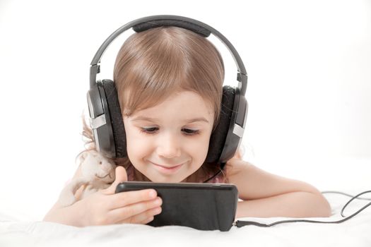 the little girl listens to music in earphones