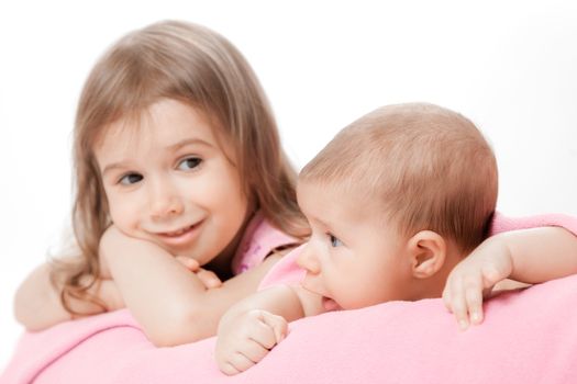 two little girls of the sisters lie on a pink plaid