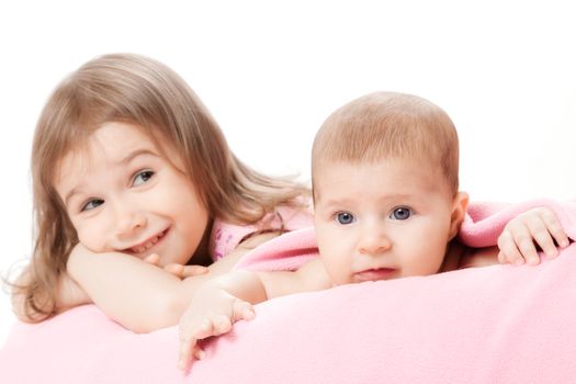 two little girls of the sisters lie on a pink plaid