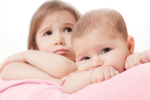 two little girls of the sisters lie on a pink plaid